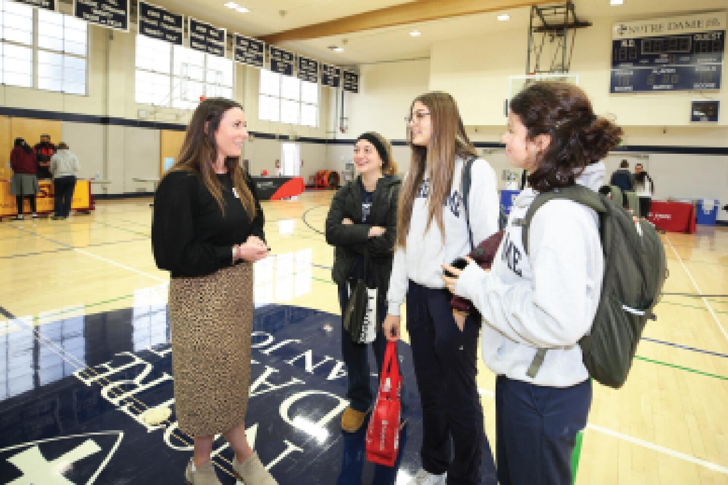 photo of Cecilia Perkins with students at the college fair in Julie Billiart Hall