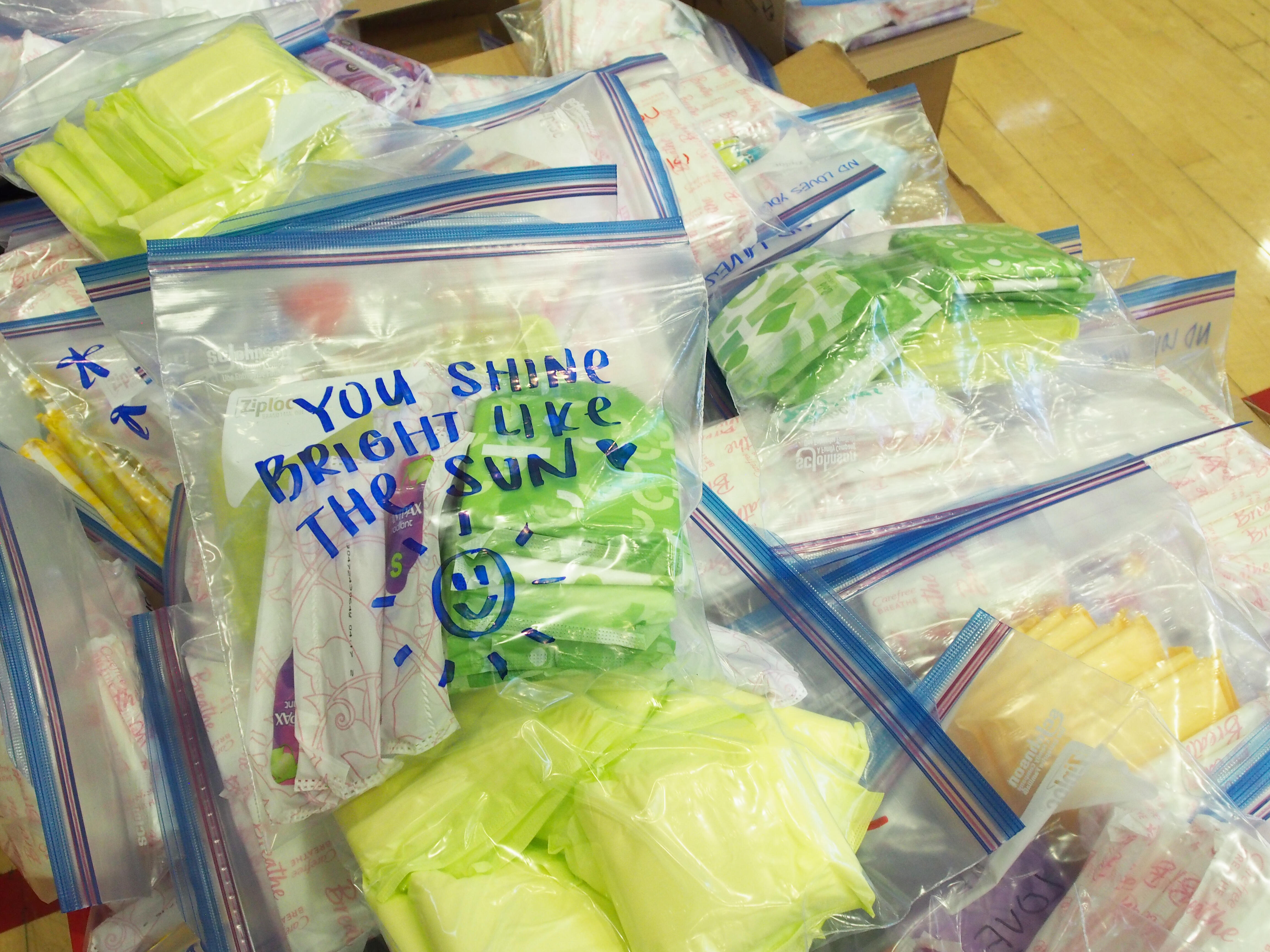 hygiene kits: one package says, "You shine bright like the sun" and a drawing of a sun with a smiley face